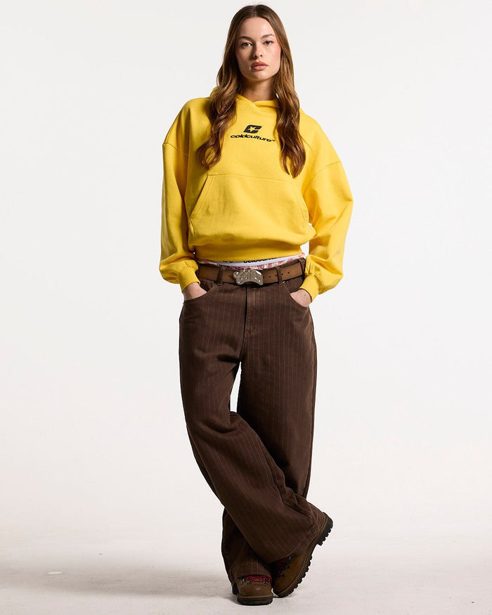 CURVED HOODIE YELLOW - yellow logo print hoodie, front view on female model - Cold Culture #woman