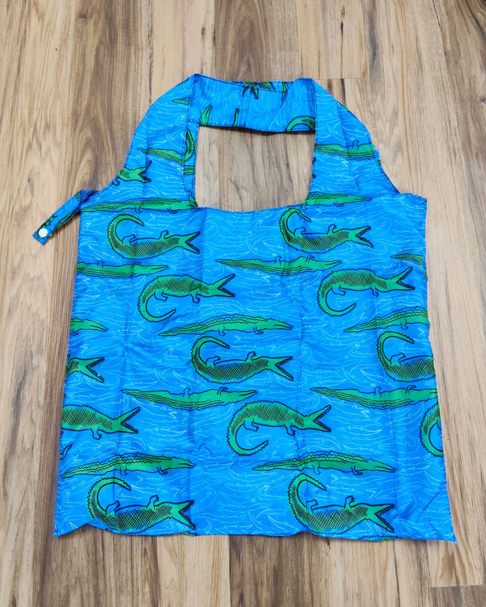 Blue crocodile printed reusable bagon a wooden surface