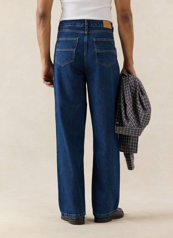 Mid wash blue Percival Pleated Denim Jeans in 12oz cotton, shown from behind with patch pockets and a leather logo patch.