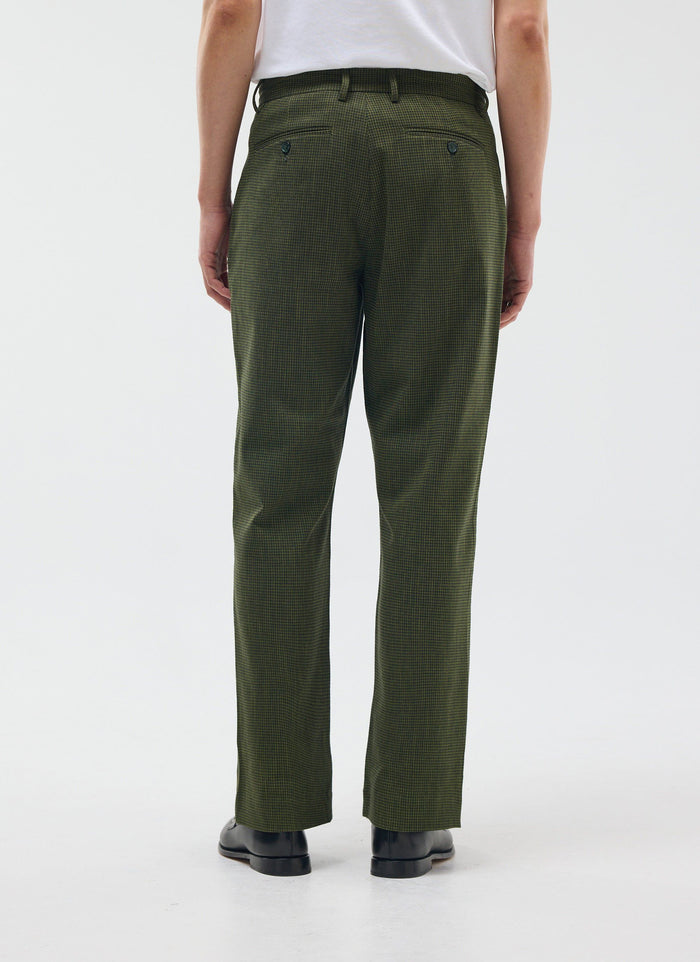 A model shot from behind wearing the Percival Pleated Tailored Trouser in a forest green houndstooth check.