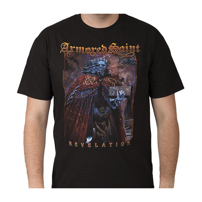 Someone wearing a black Armored Saint T-shirt with a detailed illustration of a skeletal armored figure holding a book, plus the band name and Revelation in stylized text.