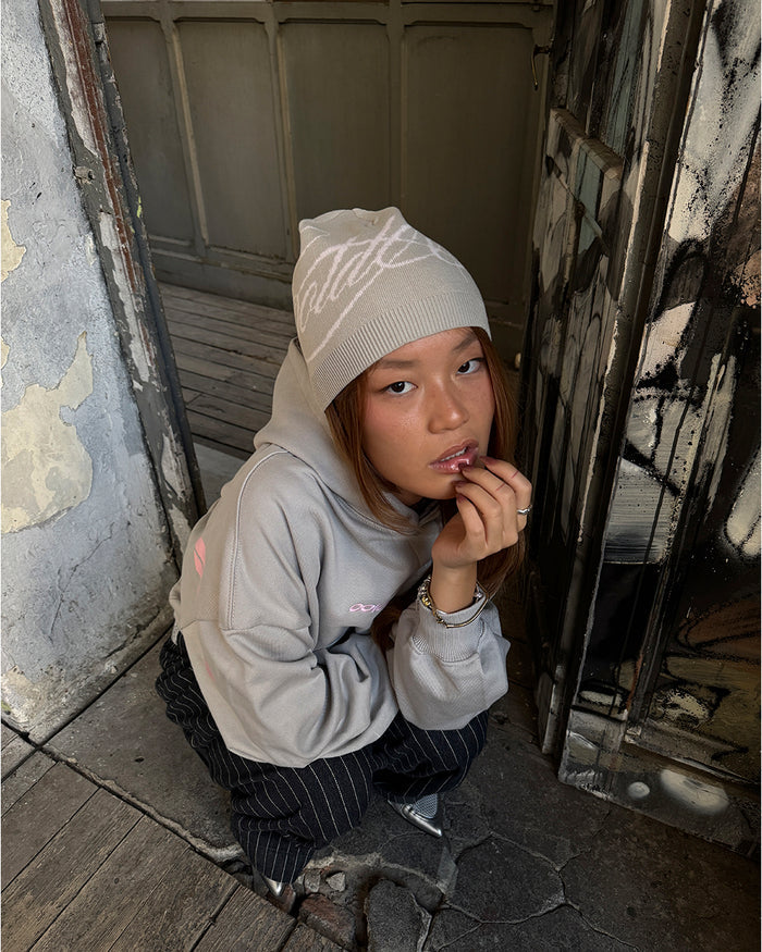 SCRIPT BEANIE BEIGE - beige script knit beanie, street style shot - Cold Culture