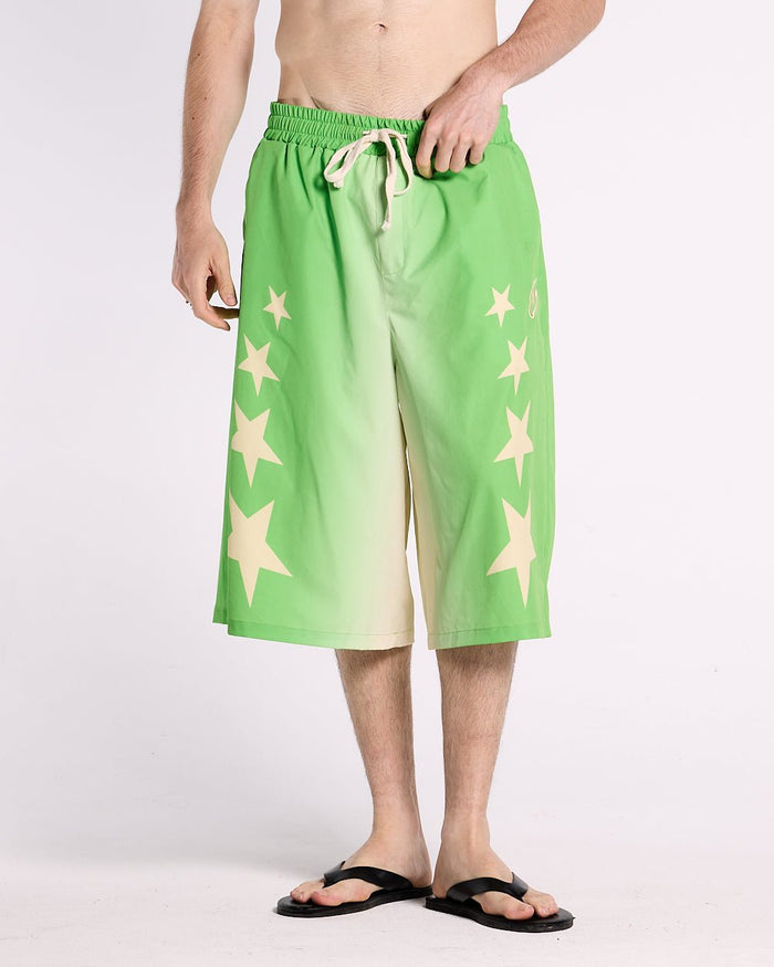 STARS WIDE SWIM SHORTS GREEN - green star print swim shorts, front view on male model - Cold Culture